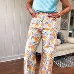 Cotton button and zipper closure bright floral pants with seams down the front of both legs and front and back pockets.