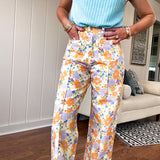 Cotton button and zipper closure bright floral pants with seams down the front of both legs and front and back pockets.