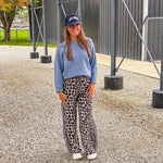 Lightweight charcoal and taupe leopard print wide leg pants with black and white stripe down the sides of the legs.
