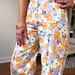 Cotton button and zipper closure bright floral pants with seams down the front of both legs and front and back pockets.