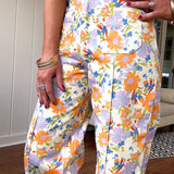 Cotton button and zipper closure bright floral pants with seams down the front of both legs and front and back pockets.