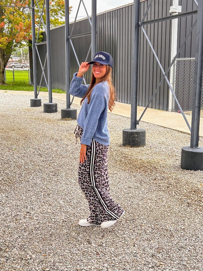 Lightweight charcoal and taupe leopard print wide leg pants with black and white stripe down the sides of the legs.
