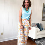 Cotton button and zipper closure bright floral pants with seams down the front of both legs and front and back pockets.
