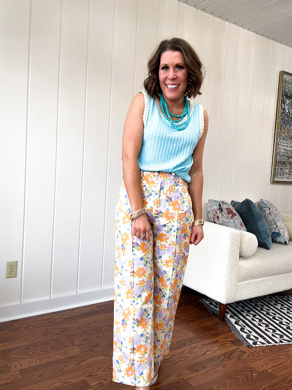 Cotton button and zipper closure bright floral pants with seams down the front of both legs and front and back pockets.