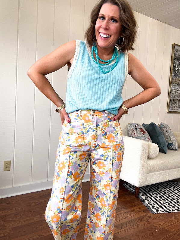 Cotton button and zipper closure bright floral pants with seams down the front of both legs and front and back pockets.
