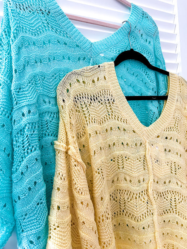 Soft, woven wide V neck sweater with 3/4 sleeves and a seashell design in the weave with exposed seams down the middle and at the shoulders. Oversized