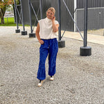 White mock neck top with modern sleeveless cut, bubble hem and slouchy neckline.
