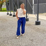White mock neck top with modern sleeveless cut, bubble hem and slouchy neckline.