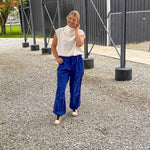 White mock neck top with modern sleeveless cut, bubble hem and slouchy neckline.
