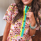 Blush and orange multi colored leopard print dress with short sleeves, 1/4 button front with yellow and teal stripes and pockets. Mini length.