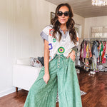 Lightweight green washed pinktuck front ultra wide leg pants with button front and drawstring.