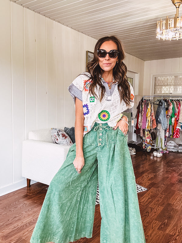 Lightweight green washed pinktuck front ultra wide leg pants with button front and drawstring.