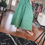 Lightweight green washed pinktuck front ultra wide leg pants with button front and drawstring.