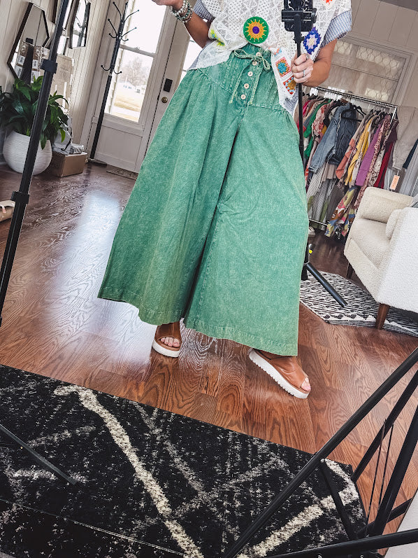 Lightweight green washed pinktuck front ultra wide leg pants with button front and drawstring.
