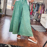 Lightweight green washed pinktuck front ultra wide leg pants with button front and drawstring.