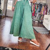 Lightweight green washed pinktuck front ultra wide leg pants with button front and drawstring.