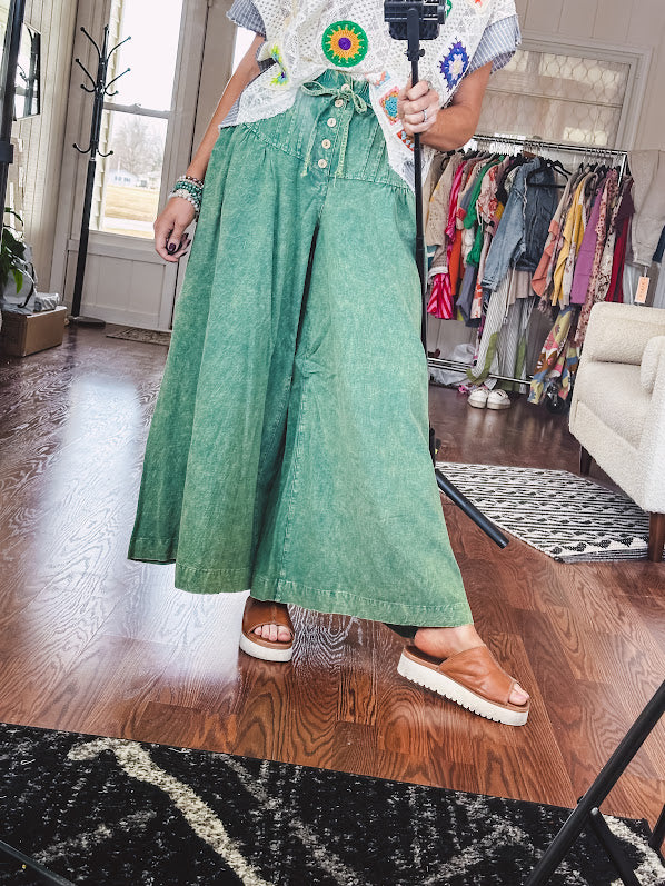 Lightweight green washed pinktuck front ultra wide leg pants with button front and drawstring.