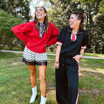 Satin shorts in cream with black polka dots and black lace at the hems with elastic waist.