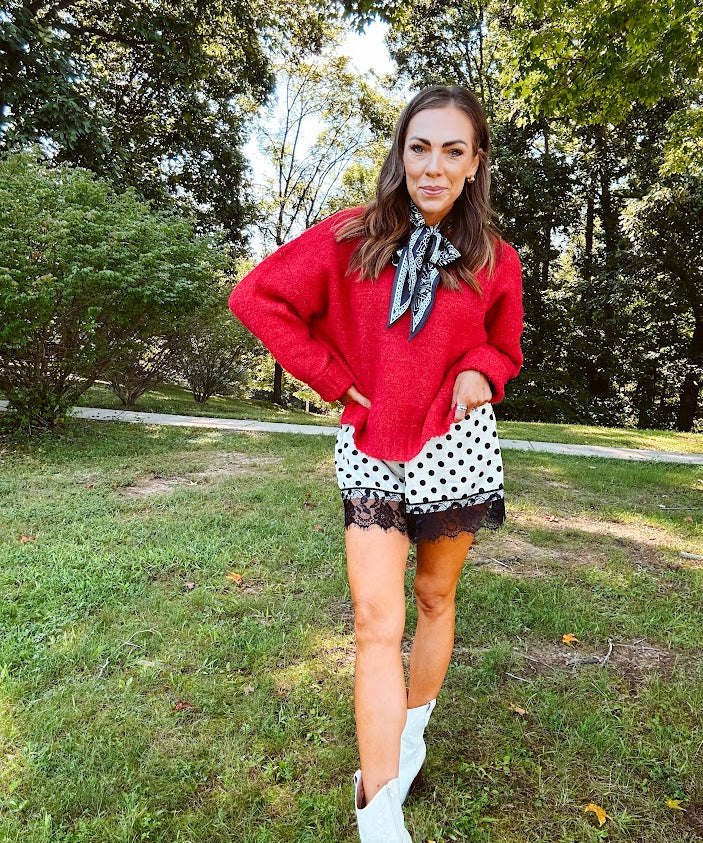 Satin shorts in cream with black polka dots and black lace at the hems with elastic waist.
