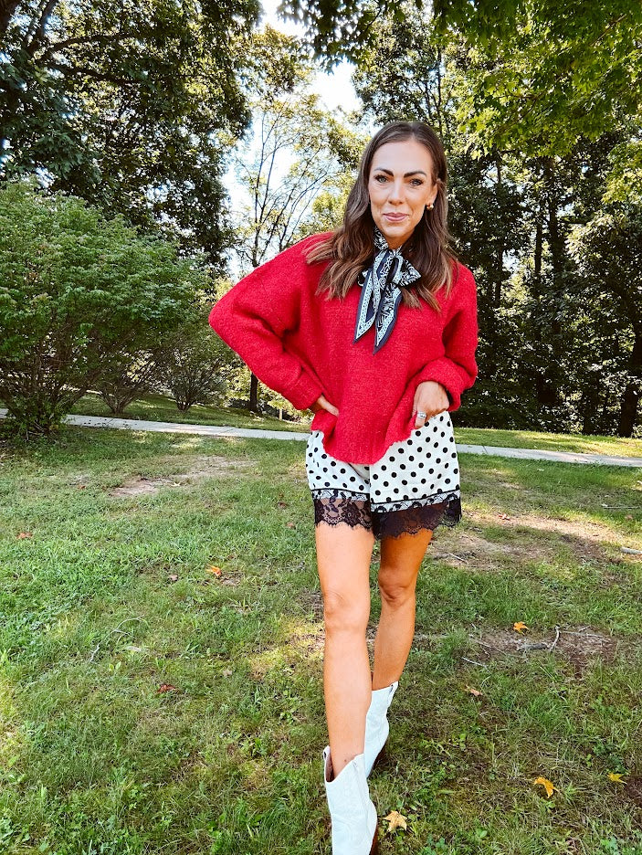 Satin shorts in cream with black polka dots and black lace at the hems with elastic waist.