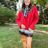 Satin shorts in cream with black polka dots and black lace at the hems with elastic waist.