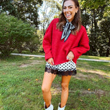 Satin shorts in cream with black polka dots and black lace at the hems with elastic waist.