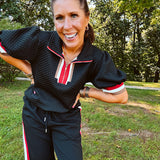 Wide leg black quilted pants with drawstring elastic waist and cream, red and taupe stripes down the legs.