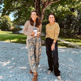 Lightweight cotton balloon pants in gray with golden florals throughout, front pleats and lace trimmed pockets. Button and zipper closure with elastic back.