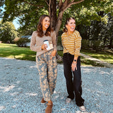 Lightweight cotton balloon pants in gray with golden florals throughout, front pleats and lace trimmed pockets. Button and zipper closure with elastic back.