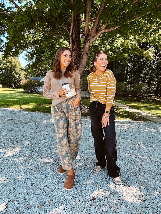 Lightweight cotton balloon pants in gray with golden florals throughout, front pleats and lace trimmed pockets. Button and zipper closure with elastic back.