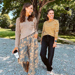 Lightweight cotton balloon pants in gray with golden florals throughout, front pleats and lace trimmed pockets. Button and zipper closure with elastic back.
