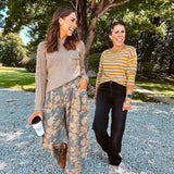 Lightweight cotton balloon pants in gray with golden florals throughout, front pleats and lace trimmed pockets. Button and zipper closure with elastic back.