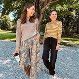 Lightweight cotton balloon pants in gray with golden florals throughout, front pleats and lace trimmed pockets. Button and zipper closure with elastic back.