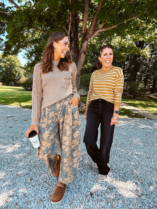 Lightweight cotton balloon pants in gray with golden florals throughout, front pleats and lace trimmed pockets. Button and zipper closure with elastic back.