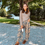 Lightweight cotton balloon pants in gray with golden florals throughout, front pleats and lace trimmed pockets. Button and zipper closure with elastic back.
