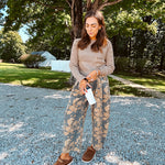 Lightweight cotton balloon pants in gray with golden florals throughout, front pleats and lace trimmed pockets. Button and zipper closure with elastic back.