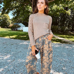 Lightweight cotton balloon pants in gray with golden florals throughout, front pleats and lace trimmed pockets. Button and zipper closure with elastic back.