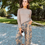 Lightweight cotton balloon pants in gray with golden florals throughout, front pleats and lace trimmed pockets. Button and zipper closure with elastic back.