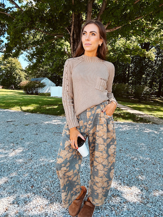 Lightweight cotton balloon pants in gray with golden florals throughout, front pleats and lace trimmed pockets. Button and zipper closure with elastic back.