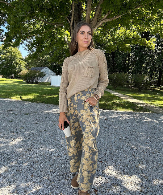 Lightweight cotton balloon pants in gray with golden florals throughout, front pleats and lace trimmed pockets. Button and zipper closure with elastic back.