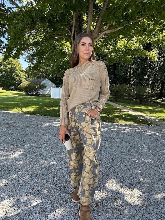 Lightweight cotton balloon pants in gray with golden florals throughout, front pleats and lace trimmed pockets. Button and zipper closure with elastic back.
