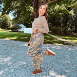 Lightweight cotton balloon pants in gray with golden florals throughout, front pleats and lace trimmed pockets. Button and zipper closure with elastic back.