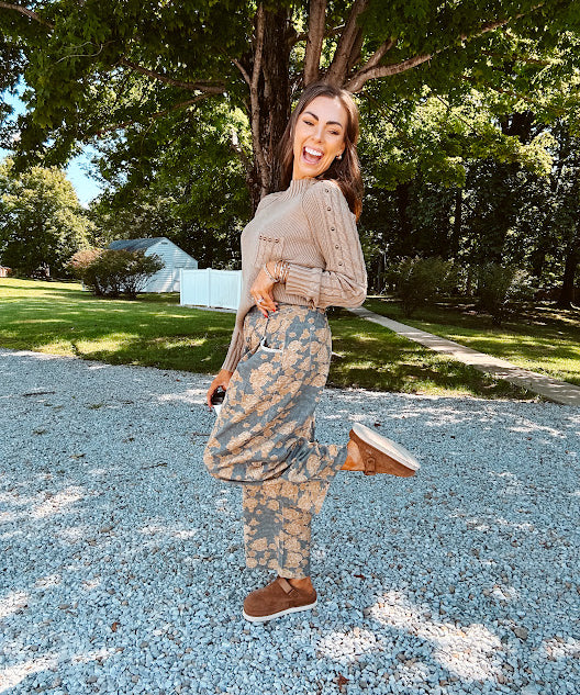 Lightweight cotton balloon pants in gray with golden florals throughout, front pleats and lace trimmed pockets. Button and zipper closure with elastic back.