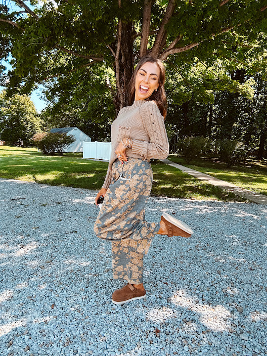 Lightweight cotton balloon pants in gray with golden florals throughout, front pleats and lace trimmed pockets. Button and zipper closure with elastic back.