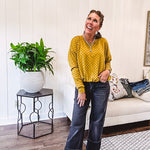 Thin, lightweight mustard long sleeved top with black polka dots throughout and elastic bubble hem.