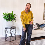 Thin, lightweight mustard long sleeved top with black polka dots throughout and elastic bubble hem.