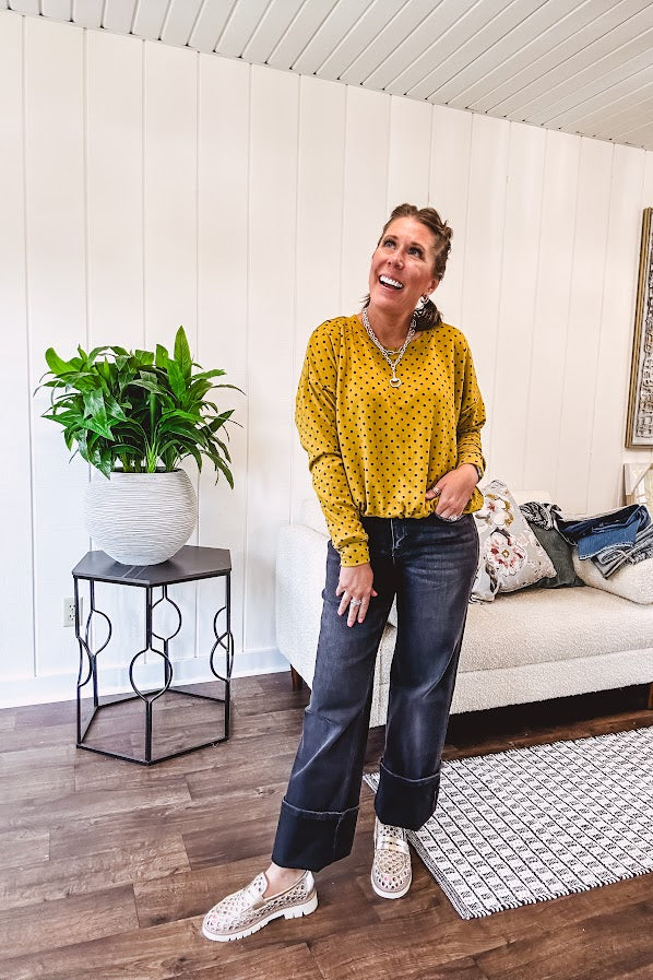 Thin, lightweight mustard long sleeved top with black polka dots throughout and elastic bubble hem.