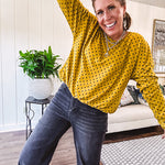 Thin, lightweight mustard long sleeved top with black polka dots throughout and elastic bubble hem.