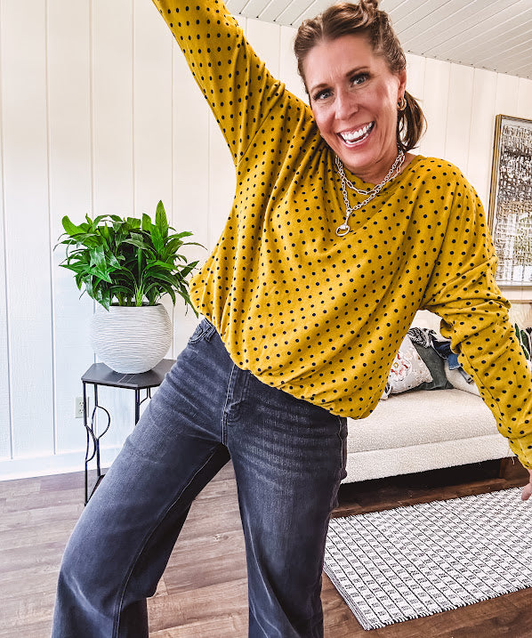 Thin, lightweight mustard long sleeved top with black polka dots throughout and elastic bubble hem.
