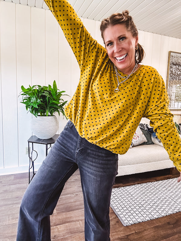 Thin, lightweight mustard long sleeved top with black polka dots throughout and elastic bubble hem.